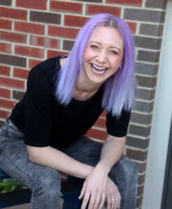 Katie is a white alt woman with light purple hair.